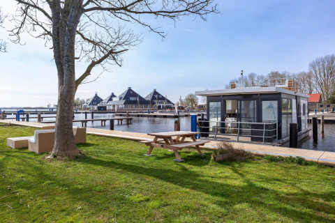 Houseboat Aqua Dolce presso Welcome In - Friesland, Paesi Bassi, vista su prato, tavolo e sull’acqua.
