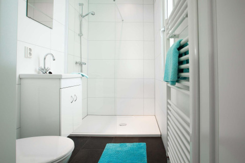 Moderne badkamer in Module Wellness (Spa) op Recreatiepark het Esmeer met witte tegels en turquoise accenten.