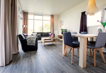 Salon moderne et lumineux dans la lodge Module Wellness (Spa) au Recreatiepark het Esmeer aux Pays-Bas.