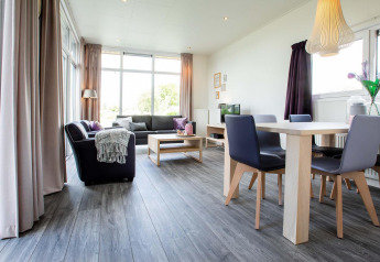 Salon moderne et lumineux dans la lodge Module Wellness (Spa) au Recreatiepark het Esmeer aux Pays-Bas.