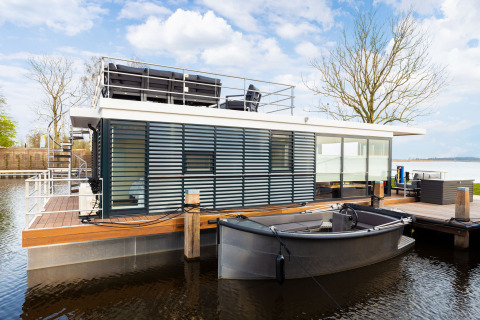 Moderne Hausboot 'de Valreep' mit Dachterrasse und Boot an Welcome In - Friesland, Niederlande.