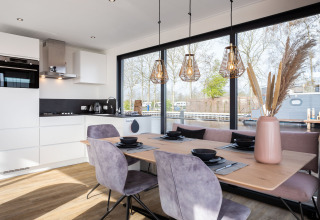Zona pranzo e cucina moderna sul houseboat 'de Valreep' a Friesland, Paesi Bassi, con grandi finestre panoramiche.