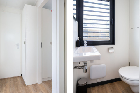 Interior de la casa flotante 'de Valreep' en Welcome In - Friesland, Países Bajos, con baño y pasillo moderno.