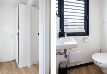 Interior de la casa flotante 'de Valreep' en Welcome In - Friesland, Países Bajos, con baño y pasillo moderno.