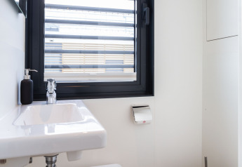 Baño moderno en la casa flotante 'de Valreep' en Welcome In - Friesland, Países Bajos, con ventana y lavabo.