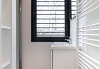 Bagno moderno sulla houseboat 'de Valreep' con finestra, lavabo e termosifone a Friesland, Paesi Bassi.