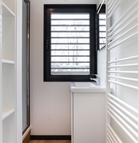 Moderne badeværelse på husbåd 'de Valreep' med vindue, håndvask og radiator, Friesland, Holland.