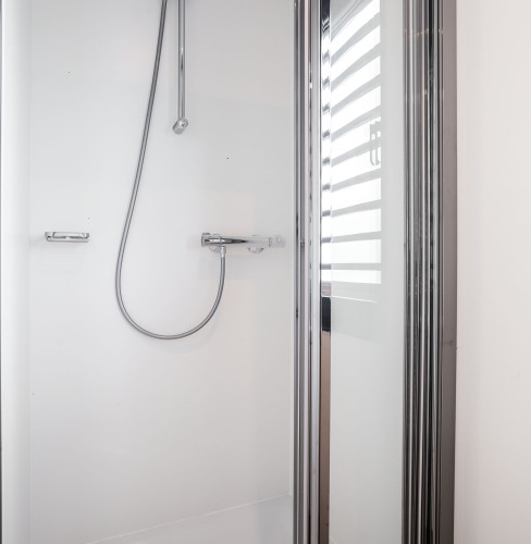 Cabina de ducha moderna con puerta de vidrio y grifería cromada en Houseboat 'de Valreep', Friesland, Países Bajos.