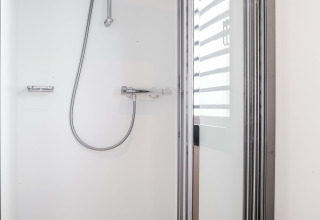 Moderne douchecabine met glazen deur en chromen kranen op Houseboat 'de Valreep', Friesland, Nederland.