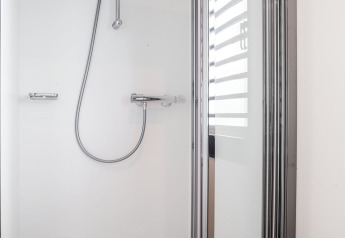 Moderne brusekabine med glasdør og krom armatur på Houseboat 'de Valreep', Friesland, Nederlandene.