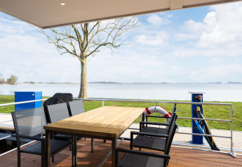 Vista desde la terraza de la casa flotante 'de Valreep' en Welcome In - Friesland, con lago y paisaje al fondo.