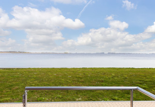 Vue depuis la péniche 'de Valreep' à Welcome In - Friesland avec pelouse et lac aux Pays-Bas.