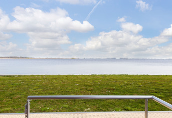 Vue depuis la péniche 'de Valreep' à Welcome In - Friesland avec pelouse et lac aux Pays-Bas.