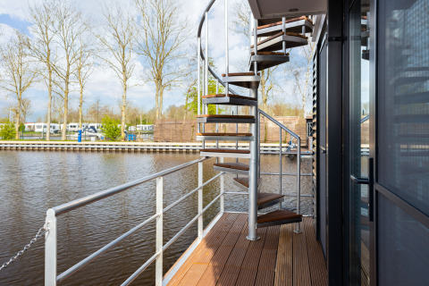 Escalera de caracol en la terraza del barco 'de Valreep' con vistas al agua en Friesland, Países Bajos.