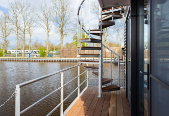 Escalera de caracol en la terraza del barco 'de Valreep' con vistas al agua en Friesland, Países Bajos.