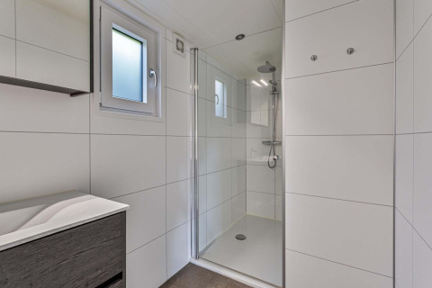 Modernes, helles Badezimmer mit Dusche in der Natuurlodge Wellness im Recreatiepark het Esmeer, Niederlande.