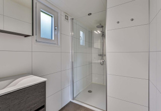 Modernes, helles Badezimmer mit Dusche in der Natuurlodge Wellness im Recreatiepark het Esmeer, Niederlande.