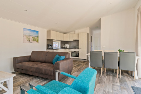 Bright living room with modern kitchen in Forest park chalet at Holiday park De Kleine Belties, Netherlands.