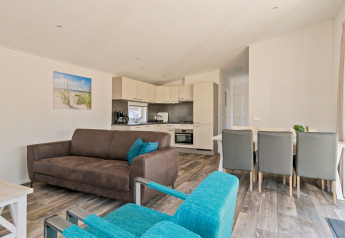 Bright living room with modern kitchen in Forest park chalet at Holiday park De Kleine Belties, Netherlands.