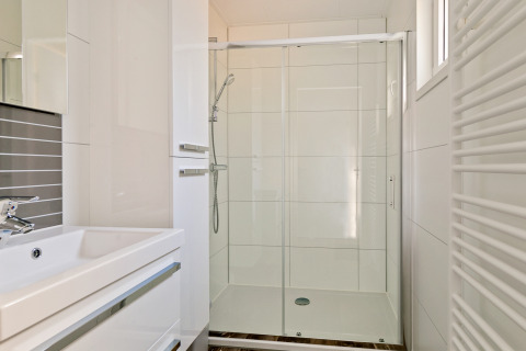 Modern bathroom with glass shower and sink at Forest park chalet, Holiday park De Kleine Belties, Netherlands.