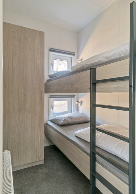 Compact bedroom with bunk beds and wardrobe at Forest park chalet, Holiday park De Kleine Belties, Netherlands.