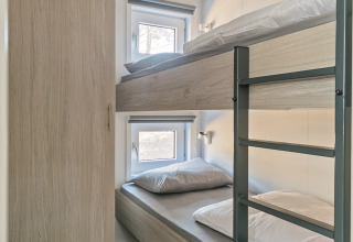 Compact bedroom with bunk beds and wardrobe at Forest park chalet, Holiday park De Kleine Belties, Netherlands.