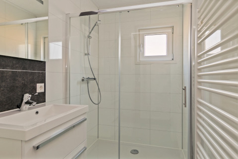 Moderne badkamer in Forest park chalet, Holiday park De Kleine Belties, Nederland, met glazen douchewand.