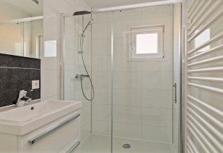 Modern bathroom at Forest park chalet, Holiday park De Kleine Belties, Netherlands, with a glass shower.