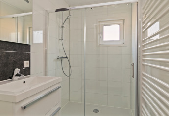 Moderne badkamer in Forest park chalet, Holiday park De Kleine Belties, Nederland, met glazen douche.