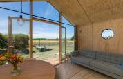 Interior view of a Wikkelhouse in Zeeland, Netherlands with modern furnishings and outdoor garden view.