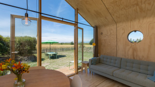 Vista interior de un Wikkelhouse en Zeeland, Países Bajos, con muebles modernos y jardín exterior visible.