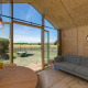 Vista interior de un Wikkelhouse en Zeeland, Países Bajos, con muebles modernos y jardín exterior visible.