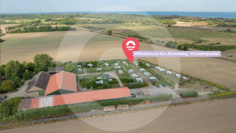 Luchtfoto van Wikkelhouse bij Welcome In - Zeeland, Nederland, omgeven door velden en vlakbij de zee.