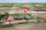 Vista aérea del Wikkelhouse en Welcome In - Zeeland, Países Bajos, rodeado de campos y cerca del mar.
