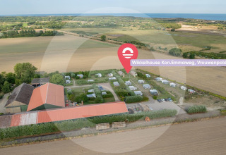 Vista aérea del Wikkelhouse en Welcome In - Zeeland, Países Bajos, rodeado de campos y cerca del mar.