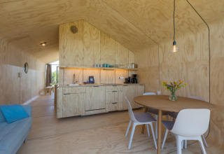 Foto interior de una moderna Wikkelhouse en Zeeland, Países Bajos, con paredes de madera y decoración minimalista.
