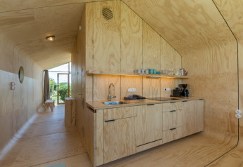Angolo cottura moderno in una Wikkelhouse a Welcome In - Zeeland, Paesi Bassi, con arredi in legno chiaro.