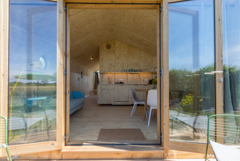 Ingang van een Wikkelhouse bij Welcome In - Zeeland, Nederland, met modern interieur en natuurzicht.