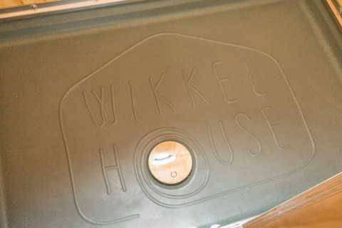 Foto de una tapa de drenaje con 'Wikkelhouse' grabado, tomada en Wikkelhouse en Zeeland, Países Bajos.