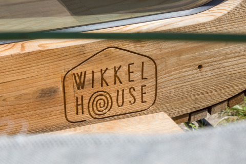 Houten bord met Wikkelhouse-logo bij Welcome In - Zeeland, Nederland.