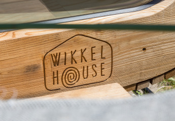 Insegna in legno con il logo Wikkelhouse presso Welcome In - Zeeland nei Paesi Bassi.