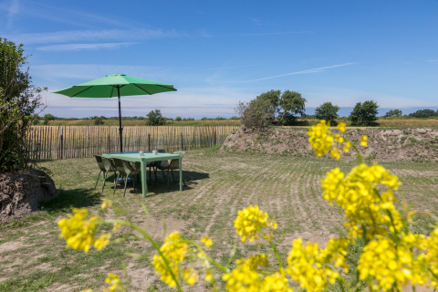 Buitentafel met groene parasol in de tuin bij Wikkelhouse op Welcome In - Zeeland, Nederland.