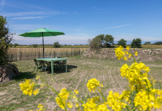 Mesa de exterior con paraguas verde en el jardín de Wikkelhouse en Welcome In - Zeeland, Países Bajos.