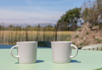 Dos tazas blancas de café sobre una mesa al aire libre en el Wikkelhouse de Zeeland, Países Bajos.
