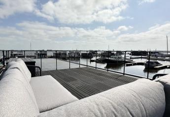 Aussicht von einer Terrasse des Hausboots 'Riggelbrug' mit Sofa, Wasser und Booten in Friesland.