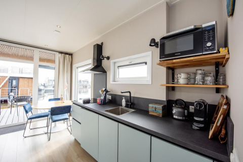 Moderne Küche mit Essbereich auf dem Hausboot 'Riggelbrug' bei Welcome In - Friesland, Niederlande, mit Mikrowelle.
