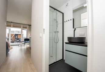 Bagno luminoso e corridoio nella Houseboat 'Riggelbrug' a Welcome In - Friesland, vista verso la terrazza.