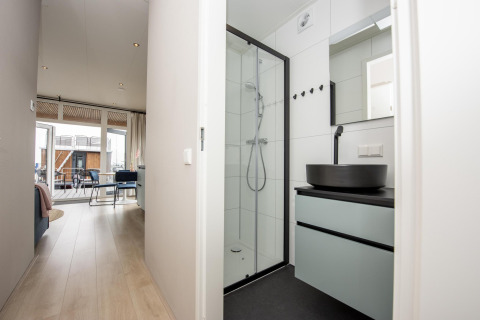 Modernes Badezimmer und Flur im Houseboat 'Riggelbrug' bei Welcome In - Friesland, mit Blick auf die Terrasse.