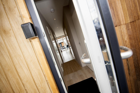 Puerta principal abierta de la Houseboat 'Riggelbrug' en Welcome In - Friesland, Países Bajos, con vista al pasillo.