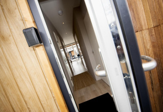 Puerta principal abierta de la Houseboat 'Riggelbrug' en Welcome In - Friesland, Países Bajos, con vista al pasillo.